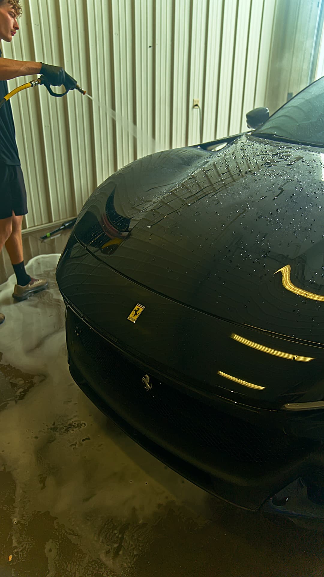 Technician rinsing a Ferrari in the Brakeout Auto wash bay
